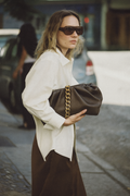 Bolso Pouch chocolate de piel vacuna con cadena dorada